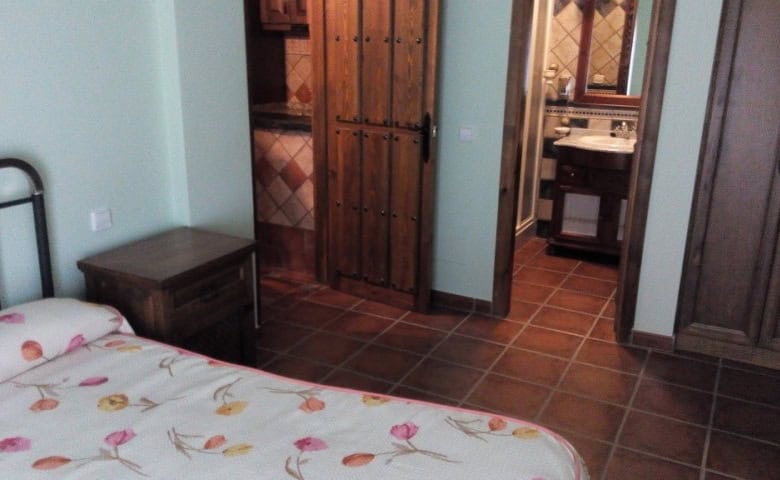 Interior view of a bedroom in Gor, Granada with wooden furniture and tiled flooring.