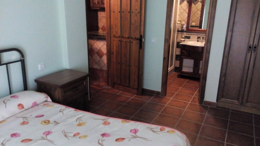 Interior view of a bedroom in Gor, Granada with wooden furniture and tiled flooring.