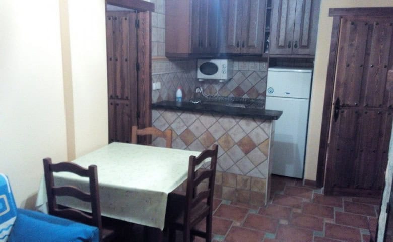 Interior view of a traditional kitchen in Gor, Granada, featuring wooden cabinets and tiled flooring.