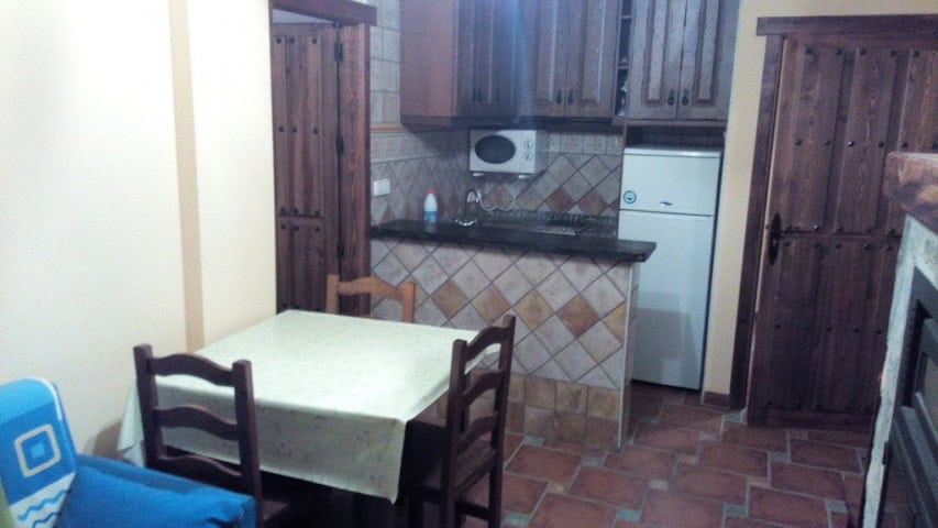 Interior view of a traditional kitchen in Gor, Granada, featuring wooden cabinets and tiled flooring.