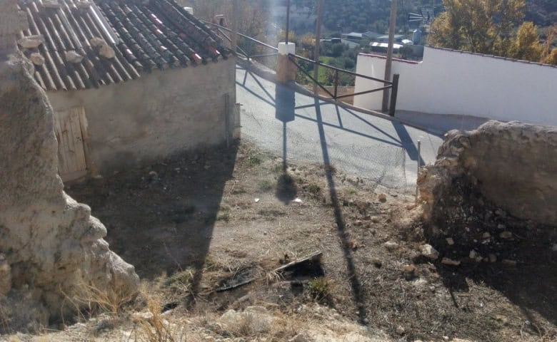 Ruin in Cuevas del Campo, Granada with stone walls and surrounding landscape.