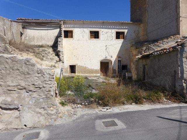 Ruin in Cuevas del Campo, Granada with weathered walls and small windows. An abandoned property in a.