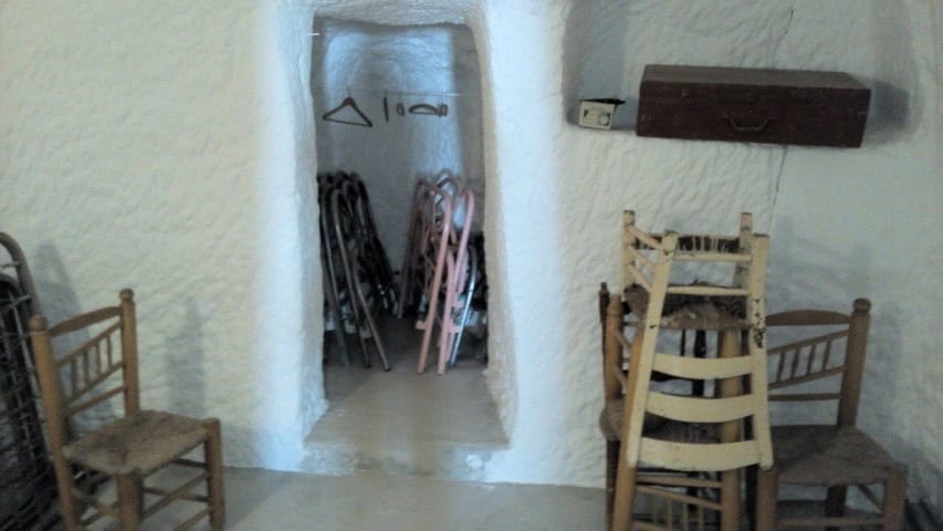 Charming cave house interior in Freila, Granada, featuring rustic furniture and unique architecture.