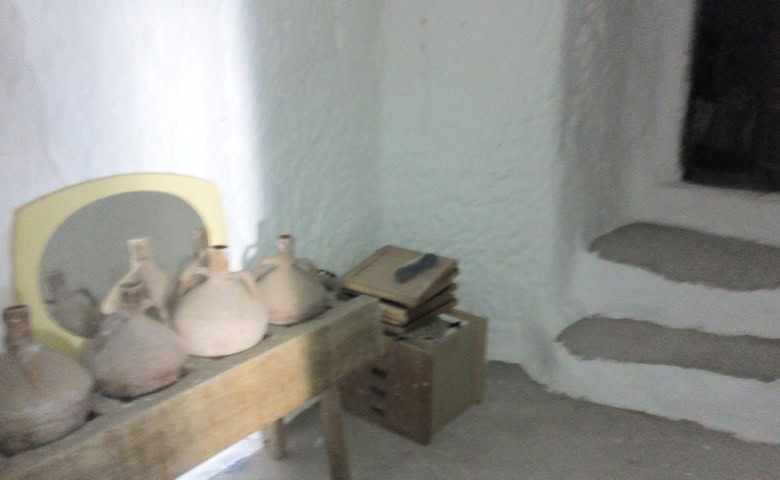 Cave house interior in Freila, Granada, showcasing rustic pottery and traditional decor.