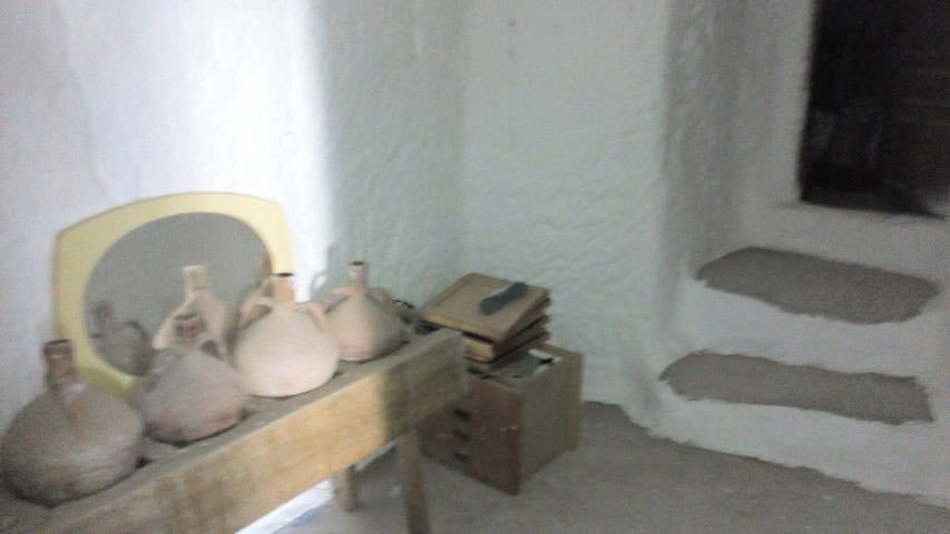 Cave house interior in Freila, Granada, showcasing rustic pottery and traditional decor.