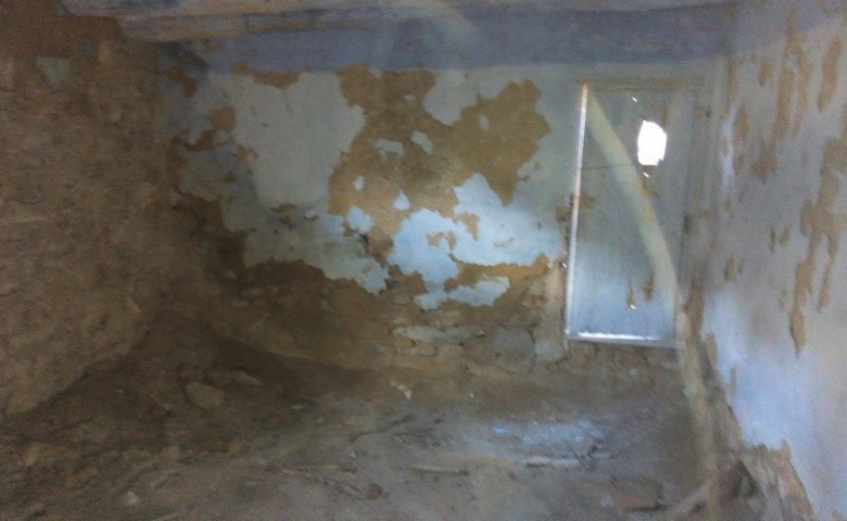 Interior of rustic farm property in Gor, Granada with weathered walls and small window.