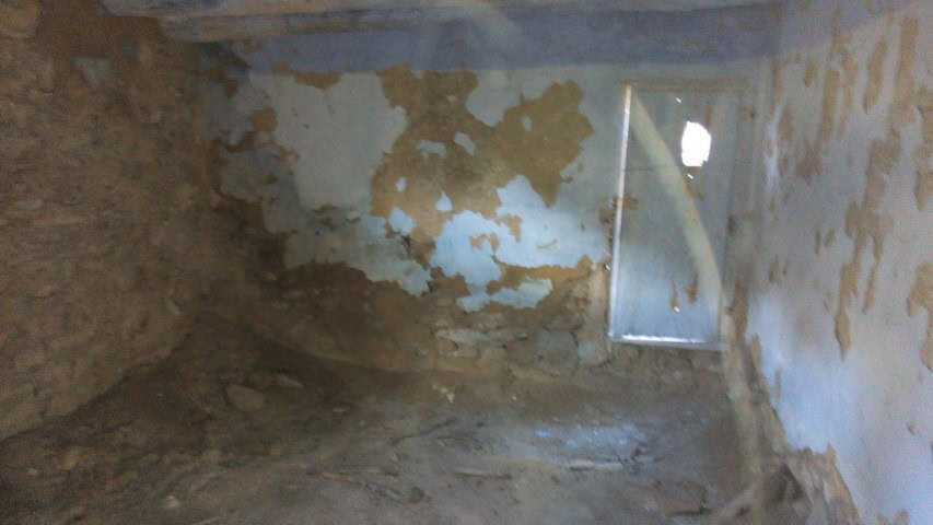 Interior of rustic farm property in Gor, Granada with weathered walls and small window.