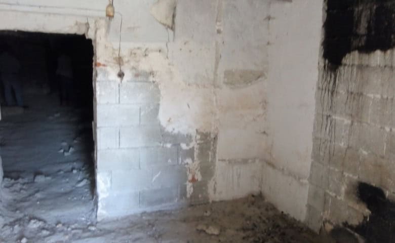 Interior view of a rustic cave house in La Alqueria, Granada, showcasing unfinished stone walls.