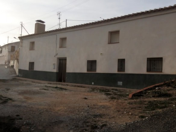 Authentic cave house in Pulpite, Granada with rustic exterior and small windows.