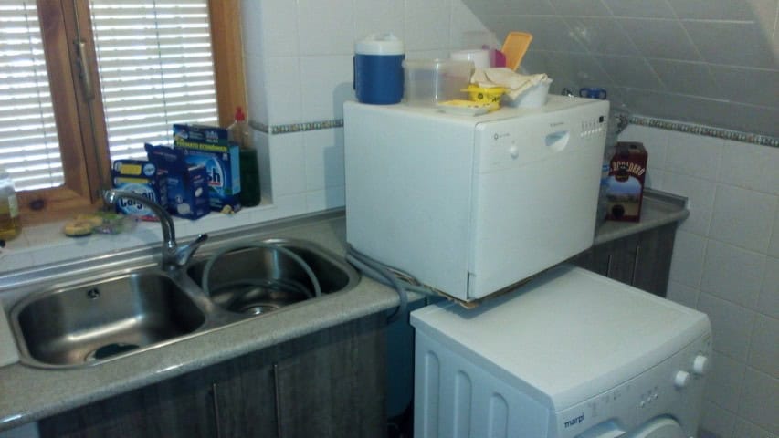 Charming cave house kitchen in Pulpite, Granada, featuring a compact sink, microwave, and essential.