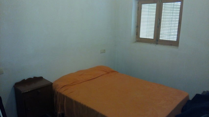 Cozy interior of a cave house in Pulpite, Granada with simple furnishings and natural light.