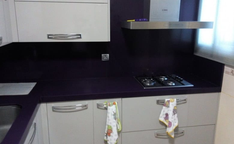 Modern kitchen with white cabinets and black countertops in Baza, Granada.