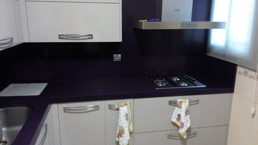 Modern kitchen with white cabinets and black countertops in Baza, Granada.
