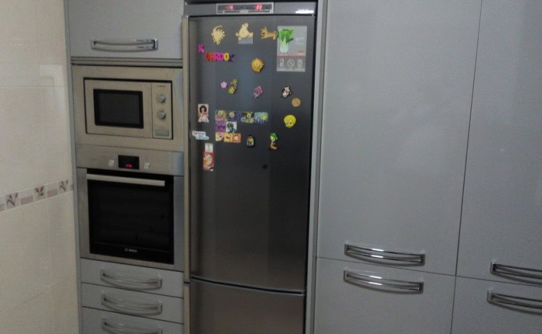 Kitchen with microwave, oven, and refrigerator in Baza, Granada.
