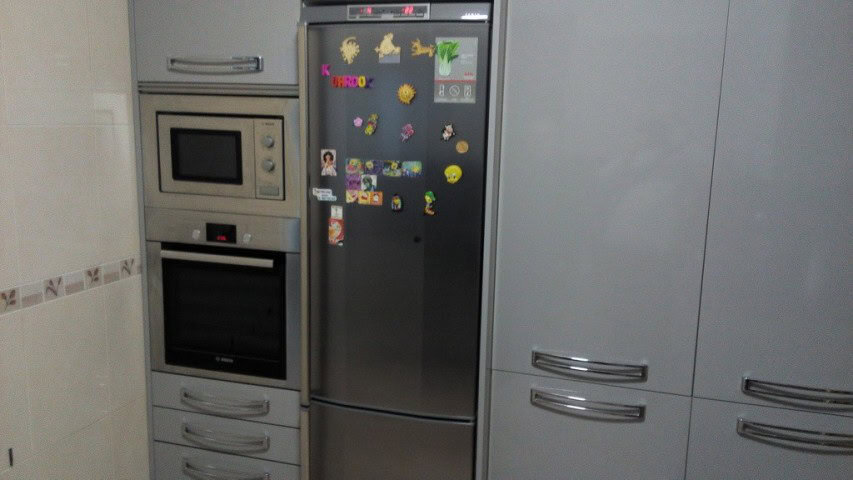 Kitchen with microwave, oven, and refrigerator in Baza, Granada.