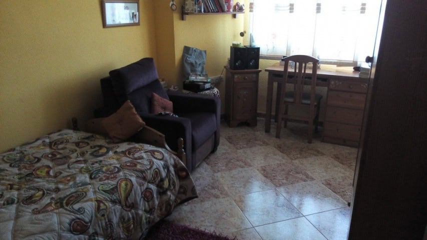 Interior view of a cozy apartment in Baza, Granada with a bed, sofa, and workspace.