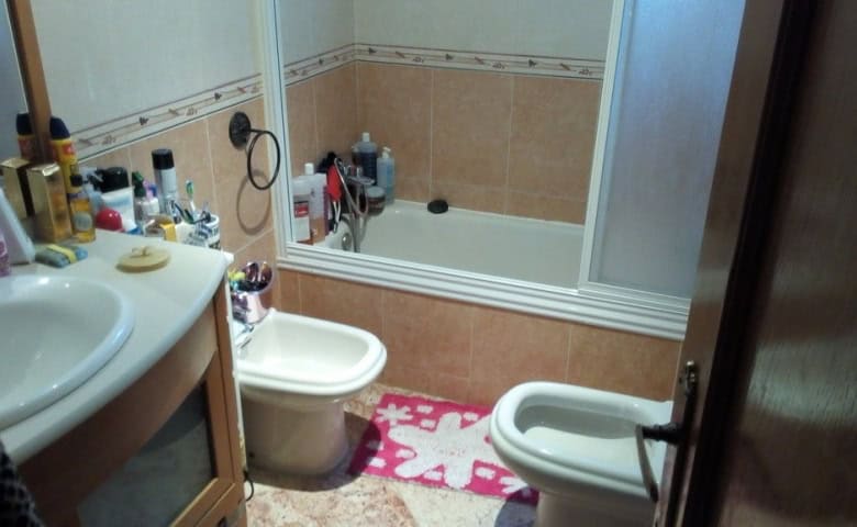 Bathroom with bathtub, sink, and bidet in Baza, Granada, featuring neutral tiles and personal care i.