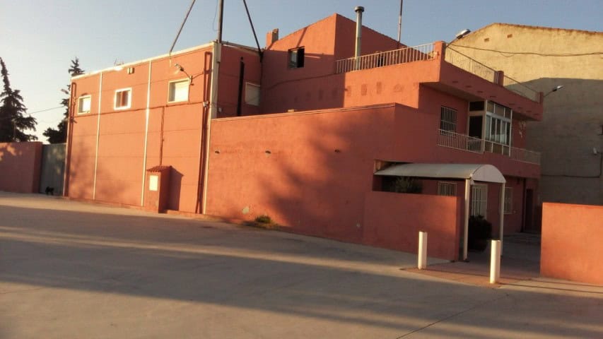 Commercial property for sale in Baza, Granada, featuring a modern building with vibrant red exterior.
