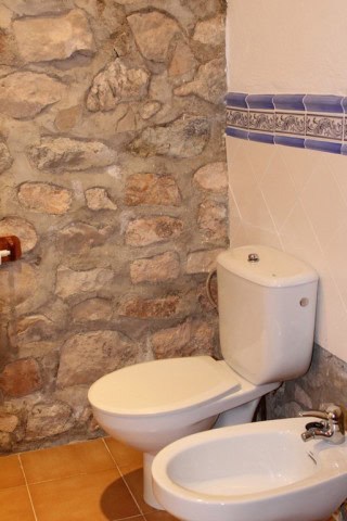 Traditional stone wall in a rustic bathroom setting.