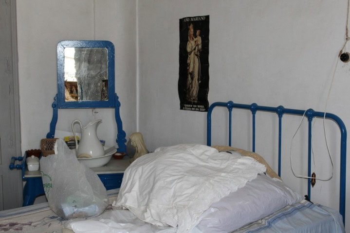 Charming bedroom in Larva, Jaen with vintage blue bed frame and rustic decor.