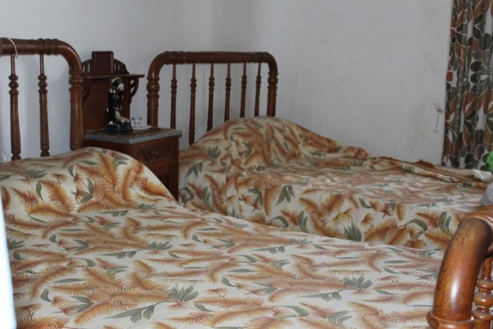 Bedroom with two single beds in a country estate in Larva, Jaen, featuring vintage wooden headboards.