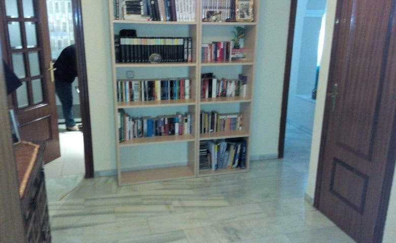 Bright apartment interior with wooden doors and a bookshelf in Baza, Granada.