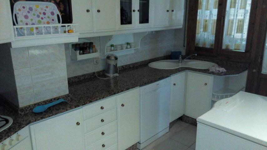 Bright kitchen in an apartment located in Baza, Granada, featuring white cabinets and modern applian.