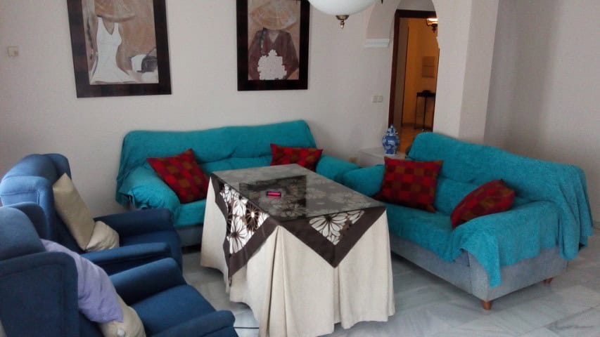 Cozy living room in a modern apartment in Baza, Granada with colorful sofas and stylish decor.