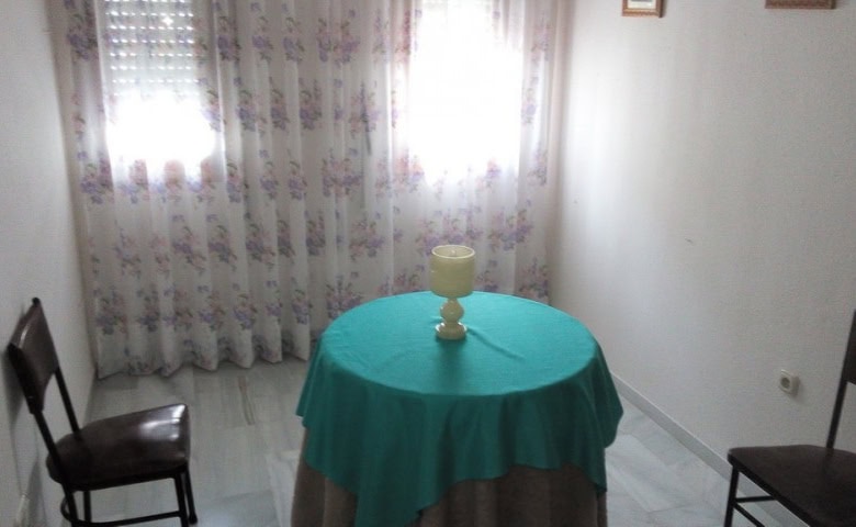 Bright interior of a small apartment in Baza, Granada, with a round table and two chairs near a wind.