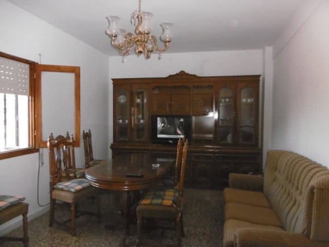 Charming living room with vintage furniture and wooden dining set in a traditional village property.