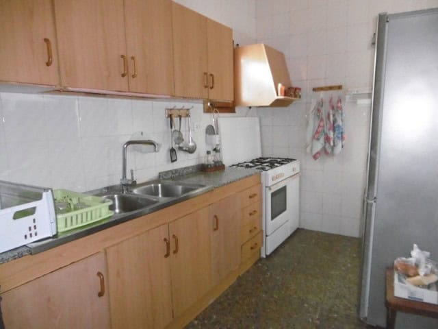 Village Property Kitchen in Cuenca, Jaen with wooden cabinets and basic appliances.