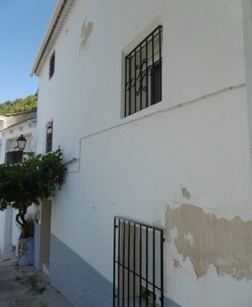 Village property in Belerda, Jaen with white walls and iron window bars. Ideal for renovation and ru.
