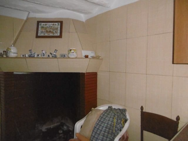 Interior of a traditional village house in Belerda, Jaen, featuring a cozy fireplace and rustic deco.