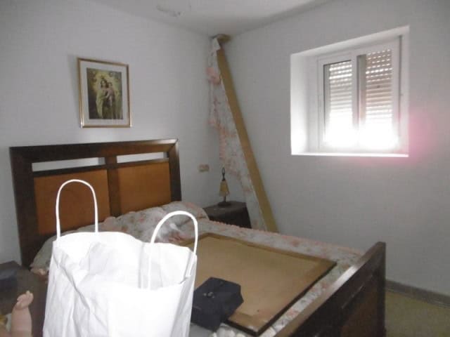 Village property in Belerda, Jaen with a simple bedroom and natural light from a window. Ideal for r.