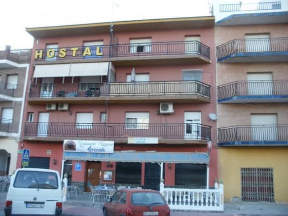 Affordable hostel building in Cuevas del Campo, Granada with balconies and commercial space.