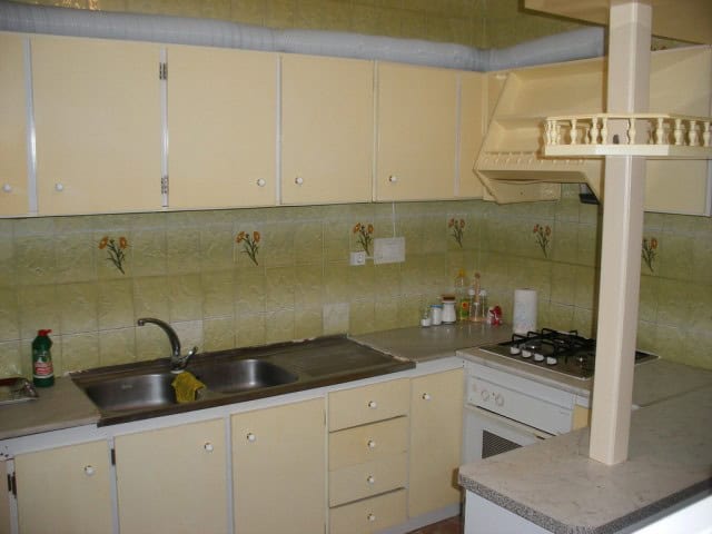 Kitchen with beige cabinets and tiled backsplash in Cuevas del Campo, Granada.