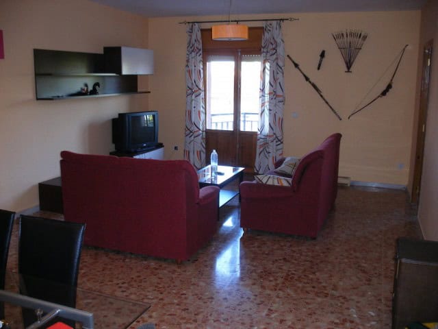 Comfortable living room with traditional decor and scenic balcony view in Cuevas del Campo.