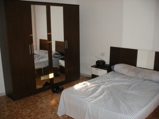 Cozy bedroom with a double bed and wardrobe in Cuevas del Campo, Granada. Perfect for comfortable li.