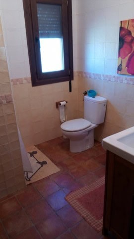 Bathroom with toilet and window in rural Tijola property.