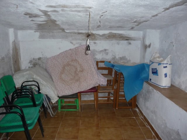 Cozy interior of a town house in Baza, Granada, showing unfinished walls and basic furnishings.