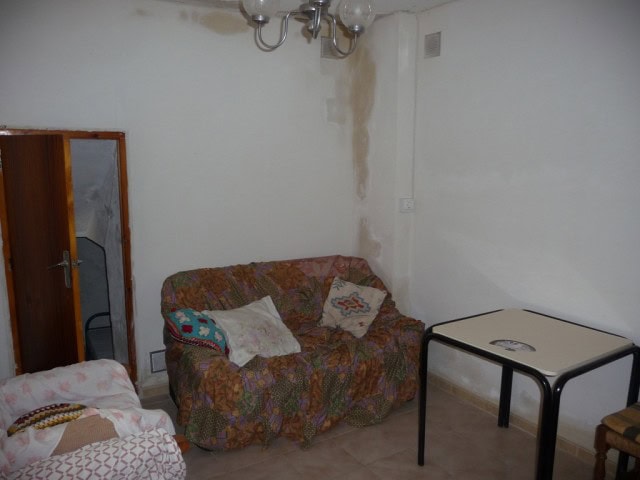Cozy living room with sofa, table, and simple decor in a town house in Baza, Granada.
