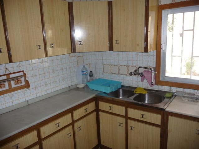 Charming kitchen of a town house in Baza, Granada, featuring wooden cabinets, a double sink, and nat.