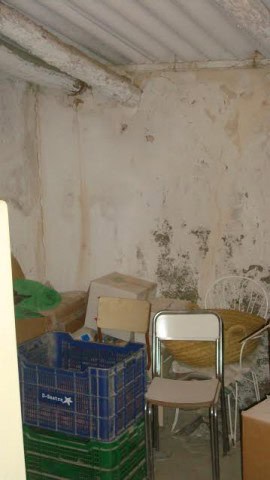 Interior view of a rustic rural property in Purchena, Almeria, showing unfinished walls and stored f.