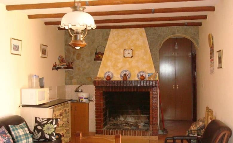 Beautiful interior of a rural property in Olula del Rio, Almeria, featuring a cozy fireplace and rus.