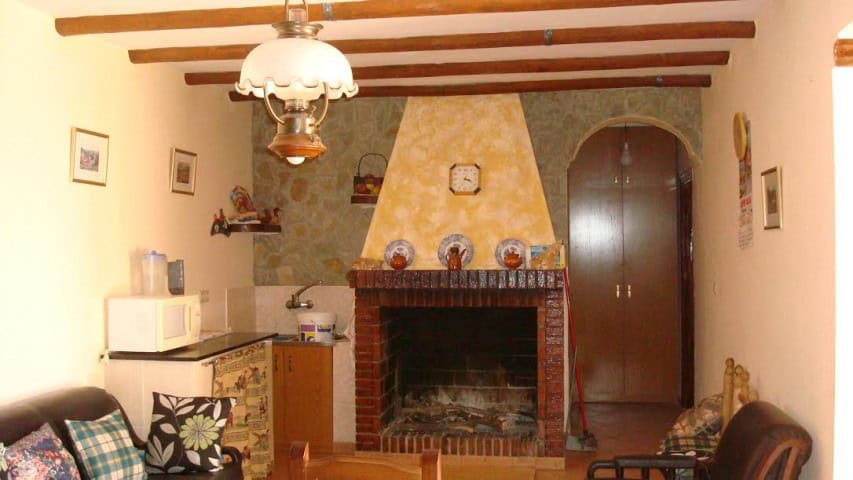 Beautiful interior of a rural property in Olula del Rio, Almeria, featuring a cozy fireplace and rus.