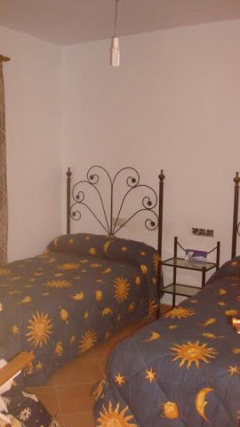 Cozy bedroom with two single beds featuring sun and moon patterned bedding in a rural property in Ol.