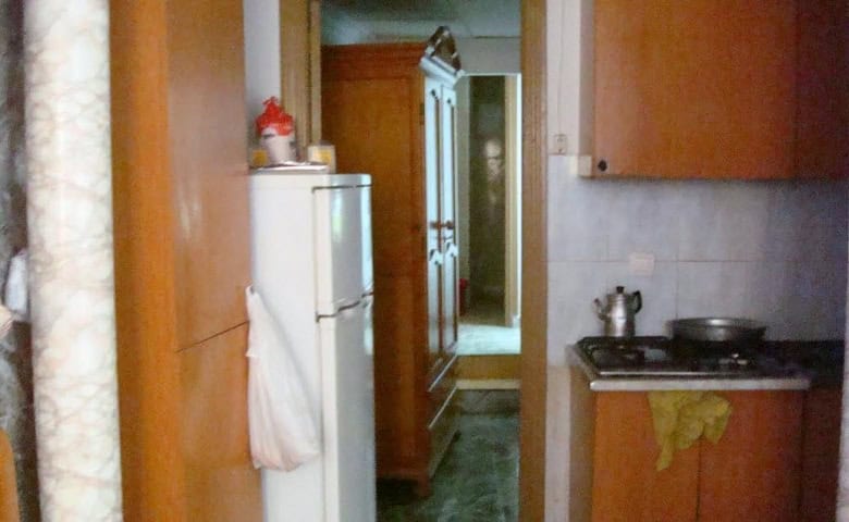 Bright kitchen in a Baza apartment, featuring wooden cabinets and modern appliances.