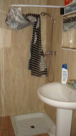 Bathroom with shower and striped towels in Baza, Granada.