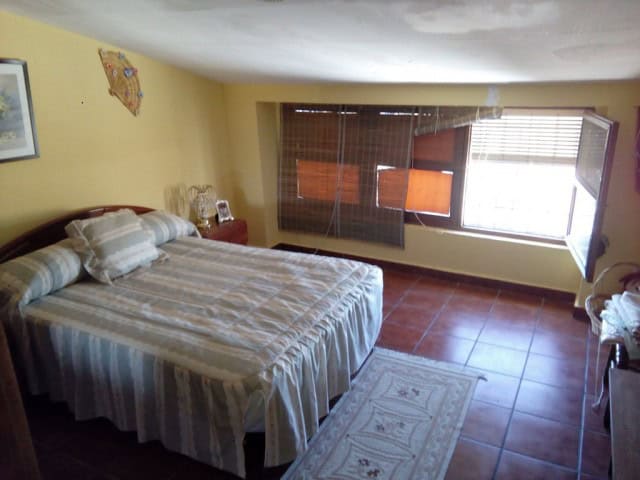 Charming bedroom in a village property in Rosales, Jaen with natural light and traditional decor.