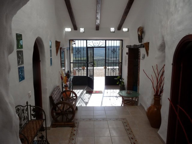 Cave house interior with rustic decor, wooden furniture, and natural light in Fontanar, Jaen.